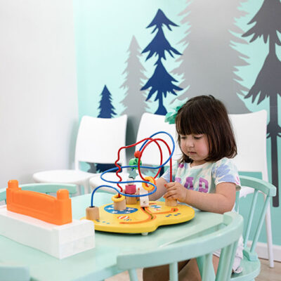 a young, adorable child playing with a problem solving toy and focusing